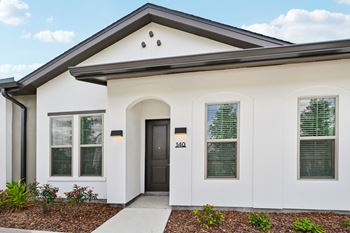 A white house with a black door and windows.